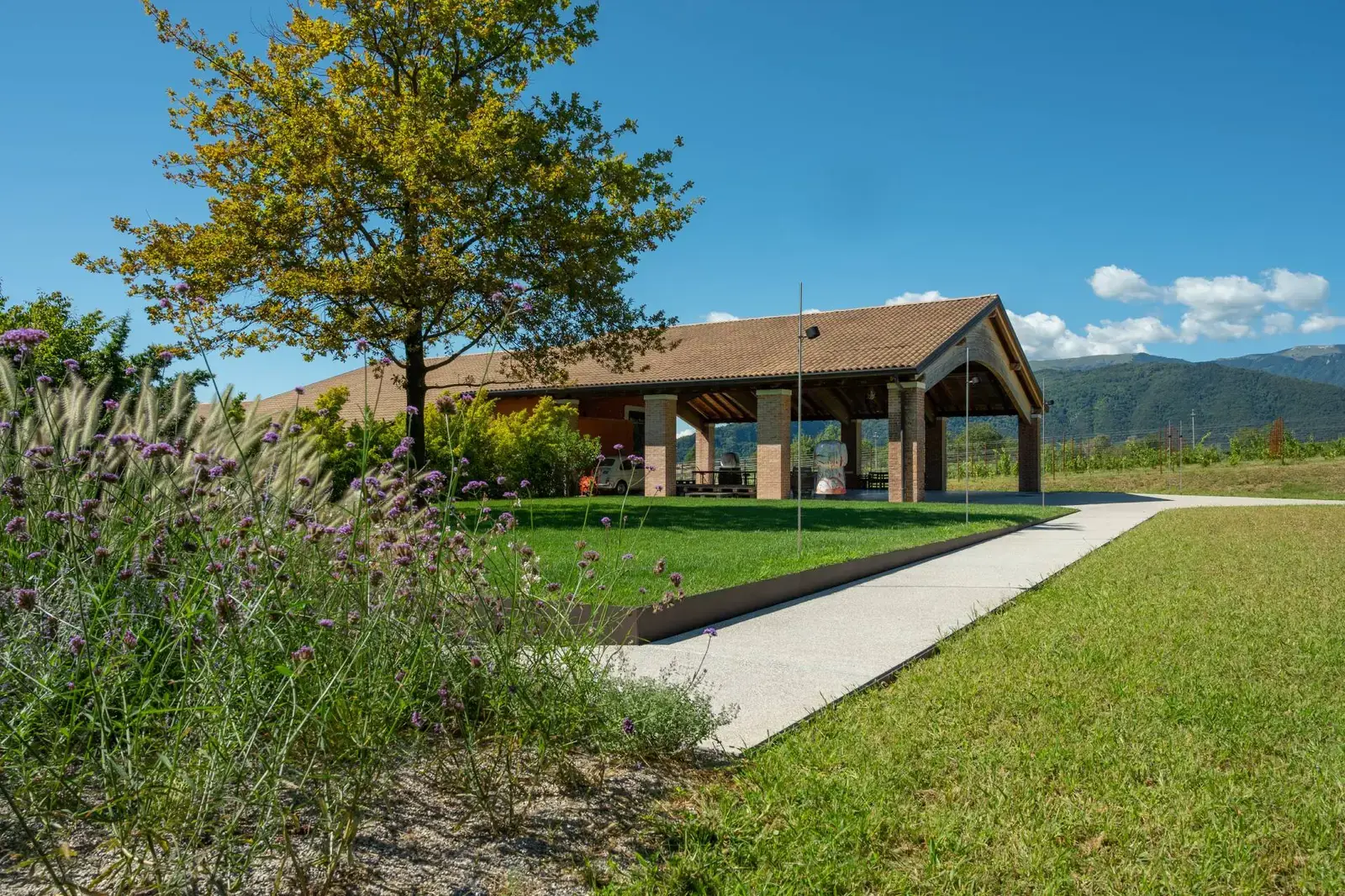 Facciata della Cantina Fasol Menin con balcone fiorito e giardino